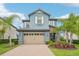 Charming two-story home featuring a two-car garage, stone accents, and well-manicured landscaping at 19191 Pease Pl, Lutz, FL 33558