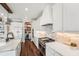Bright modern kitchen features stainless steel appliances, exposed brick, dark wood floors, and a marble island at 19191 Pease Pl, Lutz, FL 33558