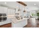 A large kitchen features a marble-topped island, white cabinetry, stainless appliances, and dark wood floors at 19191 Pease Pl, Lutz, FL 33558
