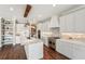Bright, modern kitchen features stainless steel appliances, exposed brick, dark wood floors, and a marble island at 19191 Pease Pl, Lutz, FL 33558