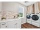 Well-lit laundry room equipped with a front-load washer and dryer and stylish brick accents at 19191 Pease Pl, Lutz, FL 33558