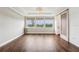Spacious living room featuring three windows with a beautiful lake view and hardwood floors at 19191 Pease Pl, Lutz, FL 33558