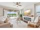 Cozy living room features hardwood floors, a ceiling fan, fireplace, and sliding glass doors with a scenic view at 19191 Pease Pl, Lutz, FL 33558