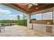 Outdoor kitchen with natural stone floors, a built in grill, and lake views at 19191 Pease Pl, Lutz, FL 33558