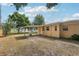 Backyard of home with large trees, grassy area, and a covered patio area at 2044 Temple Ter, Clearwater, FL 33764
