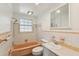 This vintage bathroom features a soaking tub and shower combination and single sink vanity at 2044 Temple Ter, Clearwater, FL 33764