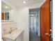 Well-lit bathroom featuring a vanity with sink and access to hallway at 2044 Temple Ter, Clearwater, FL 33764
