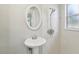 The renovated bathroom has a pedestal sink, shower with modern fixtures, and great lighting at 2044 Temple Ter, Clearwater, FL 33764