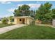 Quaint one-story home with a lush green lawn, driveway, and mature landscaping at 2044 Temple Ter, Clearwater, FL 33764