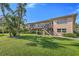 Two-story condo building with lush green lawn, mature palms, and private entrances via exterior staircases at 216 36Th N Ave # 202B, St Petersburg, FL 33704