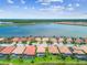 An aerial view displays residences with manicured lawns, tile roofs, and solar panels along a serene lake at 222 Toscavilla Blvd, Nokomis, FL 34275