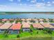 Aerial view of beautiful lakeside homes, each featuring tile roofs, screened patios, and meticulously landscaped lawns at 222 Toscavilla Blvd, Nokomis, FL 34275