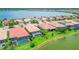 Aerial shot showcases well-maintained homes featuring screened pools and manicured landscaping near a tranquil lake at 222 Toscavilla Blvd, Nokomis, FL 34275