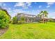 Spacious backyard featuring well-maintained lawn, mature trees, and a screened lanai, perfect for outdoor living at 222 Toscavilla Blvd, Nokomis, FL 34275
