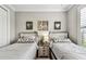 Bright bedroom with two beds, stylish decorations, and a lovely shared nightstand at 222 Toscavilla Blvd, Nokomis, FL 34275