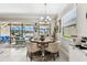 Bright dining area with a round table and chairs, next to large windows overlooking the pool at 222 Toscavilla Blvd, Nokomis, FL 34275