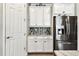 Kitchen with stainless steel refrigerator, white cabinetry, decorative tile backsplash, and granite countertop at 222 Toscavilla Blvd, Nokomis, FL 34275