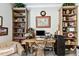 Bright home office features built-in bookshelves and a large wooden desk at 222 Toscavilla Blvd, Nokomis, FL 34275