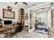 Bright home office features built-in bookshelves and a large wooden desk and hallway at 222 Toscavilla Blvd, Nokomis, FL 34275