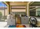 Outdoor kitchen featuring a built-in grill, mini refrigerator, and a tile backsplash at 222 Toscavilla Blvd, Nokomis, FL 34275
