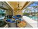 Inviting covered patio with stylish furniture, ceiling fans, and a view of the sparkling pool at 222 Toscavilla Blvd, Nokomis, FL 34275