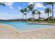 Resort style community pool overlooking the lake with lounge chairs at 222 Toscavilla Blvd, Nokomis, FL 34275