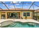 The pool features a covered patio, complete with outdoor kitchen, seating, and access to a beautiful lake view at 222 Toscavilla Blvd, Nokomis, FL 34275