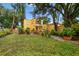 Spacious backyard with lush lawn, mature trees, and a yellow house at 2227 Brevard Ne Rd, St Petersburg, FL 33704