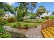 Lush backyard features a stone walkway, mature trees and a wooden fence at 2227 Brevard Ne Rd, St Petersburg, FL 33704