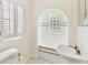 Bright bathroom with tiled tub, glass block window, and vintage-style fixtures at 2227 Brevard Ne Rd, St Petersburg, FL 33704