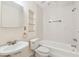 Cozy bathroom with a tub/shower combo, pedestal sink, and tiled walls at 2227 Brevard Ne Rd, St Petersburg, FL 33704