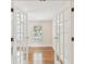 Bright bedroom with hardwood floors, shuttered window, and glass French doors at 2227 Brevard Ne Rd, St Petersburg, FL 33704
