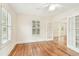 Bright living room with hardwood floors, shutters, and glass doors to an outdoor balcony at 2227 Brevard Ne Rd, St Petersburg, FL 33704