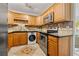 Efficient kitchen with stainless steel appliances, wood cabinets, and built-in laundry at 232 36Th N Ave # 202C, St Petersburg, FL 33704