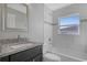 A tiled bathroom with a granite vanity, toilet and shower/tub combo with a small window at 23440 Corinne Ave, Port Charlotte, FL 33980