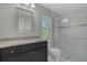 A bathroom with a granite vanity, mirror, toilet and glass-enclosed shower with a small window at 23440 Corinne Ave, North Port, FL 34288