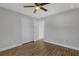 A bedroom with a closet, ceiling fan, and wood-look flooring; and a door that leads to another room at 23440 Corinne Ave, Port Charlotte, FL 33980