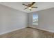 A bright bedroom featuring a window, ceiling fan, wood-look floors, and neutral wall color at 23440 Corinne Ave, Port Charlotte, FL 33980