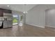 Dining area with wood-look flooring, light gray walls, vaulted ceilings, and sliding glass doors to patio at 23440 Corinne Ave, North Port, FL 34288