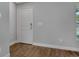 Clean entryway with light gray walls, wood-look flooring, and a white door at 23440 Corinne Ave, Port Charlotte, FL 33980
