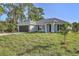 Charming single-story home featuring a well-manicured lawn, attached garage, and neutral color palette at 23440 Corinne Ave, Port Charlotte, FL 33980