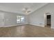 Spacious living room with wood-look floors, light gray walls, and a vaulted ceiling with a ceiling fan at 23440 Corinne Ave, Port Charlotte, FL 33980