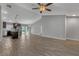 Open-concept living space with vaulted ceilings, gray walls, wood-look floors, and a modern ceiling fan at 23440 Corinne Ave, Port Charlotte, FL 33980