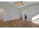 A bedroom with wood-look floors, a fan, and 2 entry ways to the bathroom and closet at 23440 Corinne Ave, Port Charlotte, FL 33980