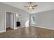 A bedroom with wood-look floors, a fan, windows, and 2 entry ways to the bathroom and closet at 23440 Corinne Ave, North Port, FL 34288