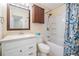 Bathroom with a shower-tub combo, white vanity, and a wood-look wall cabinet at 2700 Bayshore Blvd # 497, Dunedin, FL 34698