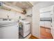 Convenient laundry room with washer, dryer, shelving, and tile flooring near kitchen at 2700 Bayshore Blvd # 497, Dunedin, FL 34698