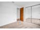 This carpeted bedroom features a mirrored closet and neutral walls at 2749 Countryside Blvd # 20, Clearwater, FL 33761