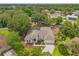 Aerial view of a beautifully landscaped home with a three-car garage and lush surroundings at 2901 Laurel Meadow Ct, Plant City, FL 33566