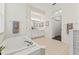 Bright bathroom featuring a tiled tub, tiled floors, and double vanity at 2901 Laurel Meadow Ct, Plant City, FL 33566
